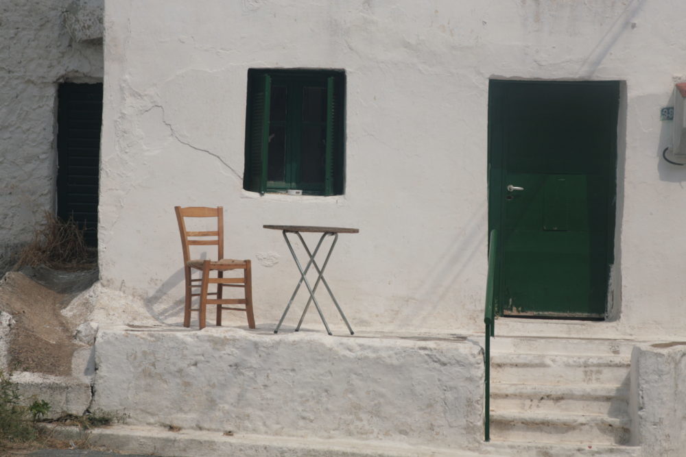 Sedia e tavolo fuori da una casa. Nell'invidia nessuno vince.